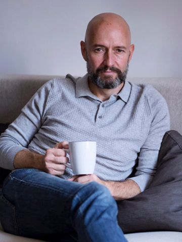 Proyecto Emo foto de hombre con barba sentado con taza