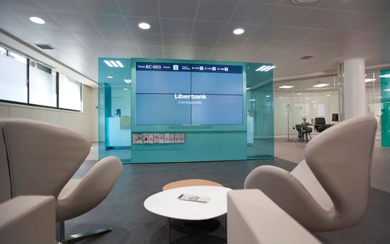 Proyecto Emo vista trasera de sillones modernos grises hacia pantalla grande liberbank